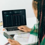 A laptop open to a freelancing platform dashboard with a six-figure earnings chart.