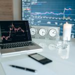 A person analyzing financial charts on a laptop, contemplating day trading for a living.