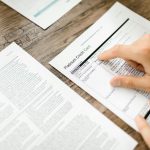 A lawyer shaking hands with a client over a contingency fee agreement.