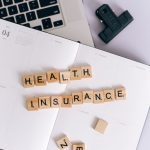 A freelancer comparing health insurance plans on a laptop.