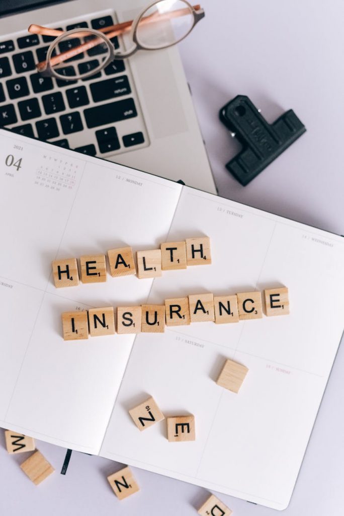 A freelancer comparing health insurance plans on a laptop.